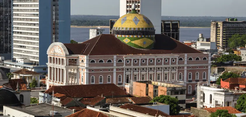 Imagem mostra o Teatro Amazonas, em meio a cidade de Manaus. 