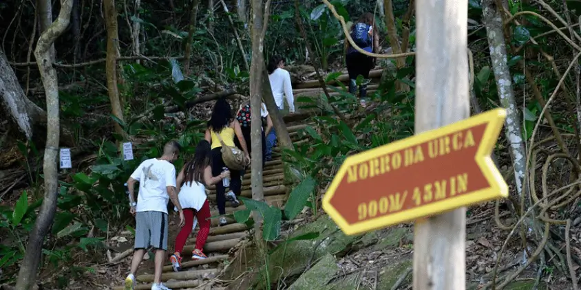 Imagem mostra algumas pessoas subindo as escadas da trilha do morro da Urca