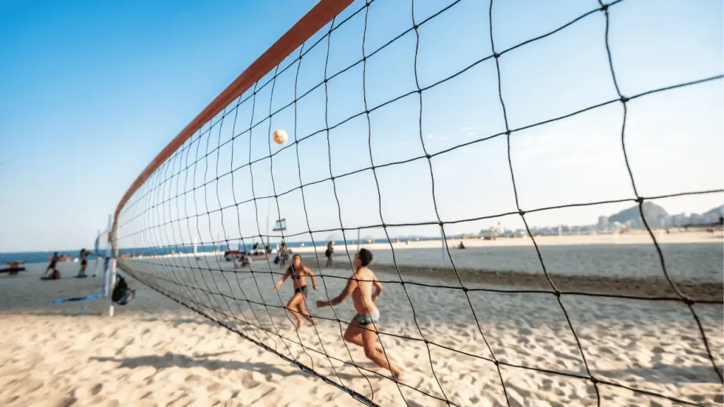 Pessoas jogando futevôlei nas areias da praia de Copacabana.