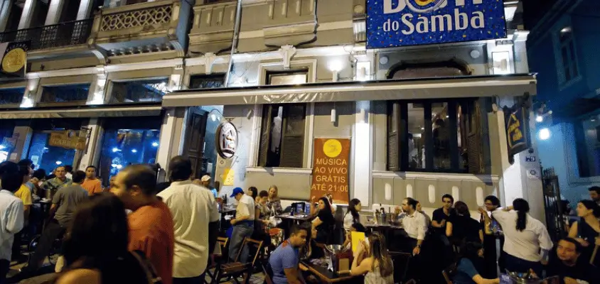 Imagem da frente do bar Carioca da Gema, com muitas pessoas sentadas nas mesas externas